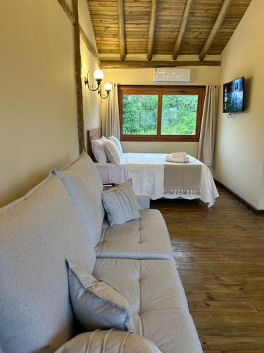 a living room with a couch and a bed at Pousada Pequeno Oásis in Tiradentes