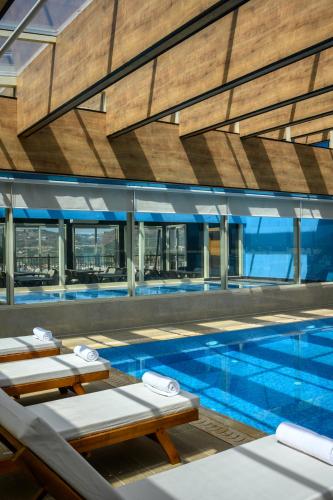 a swimming pool with chaise lounge chairs and a large building at Oaks Hotel  in Golan Heights