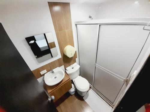 a bathroom with a shower and a toilet and a sink at Karin Hotel in Ríohacha