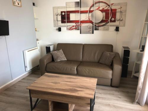 Una sala de estar con un sofá y una mesa de café. en Studio chaleureux avec piscine, en Le Barcarès