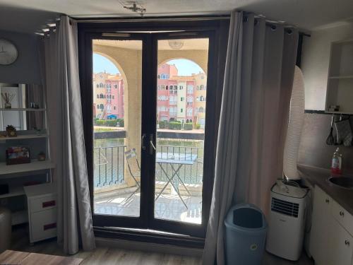 Cette chambre dispose d'une porte donnant sur un balcon. dans l'établissement Studio chaleureux avec piscine, au Barcarès