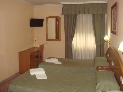 a hotel room with a bed and a couch at Hotel PAYRO in Santiago de Compostela