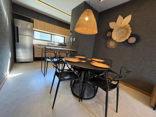 a kitchen with a table with chairs and a refrigerator at VILLAS M PATACHO - Aluga Apto F001 in Pôrto de Pedras