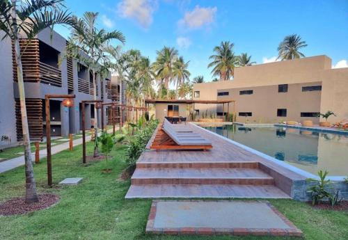 a house with a swimming pool and palm trees at VILLAS M PATACHO - Aluga Apto F001 in Pôrto de Pedras