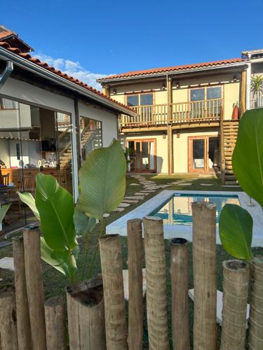 a fence in front of a house with a pool at Pousada Pequeno Oásis in Tiradentes
