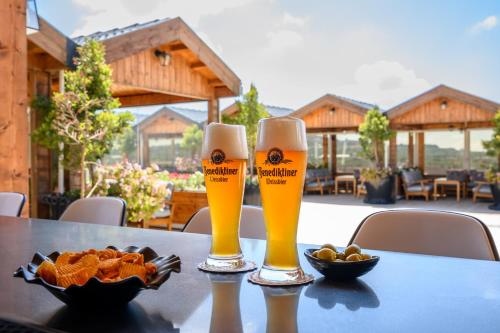 two glasses of beer and a plate of food on a table at Oaks Hotel  in Golan Heights