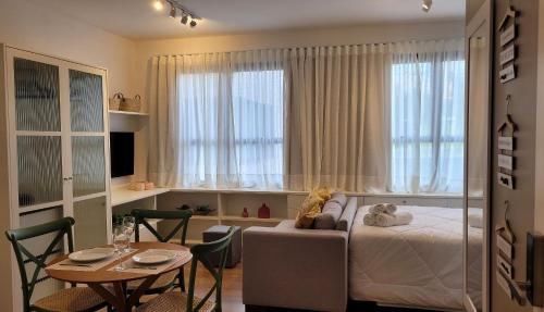 a bedroom with a bed and a table and a table and chairs at Blend Coliving One - 1 in Ribeirão Preto