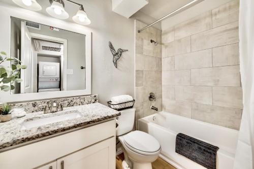 a bathroom with a toilet and a sink and a mirror at Global Cup Insta-Worthy Flat and Arboretum Tickets Included in Dallas