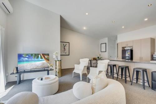 a living room with a couch and a kitchen at Golden Retreat, Central Mount Maunganui in Mount Maunganui