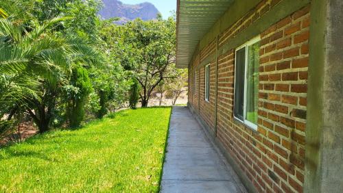 a sidewalk next to a brick building with a window at Rancho El Venado Termales in Acatic