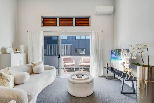 a living room with a couch and a table at Golden Retreat, Central Mount Maunganui in Mount Maunganui