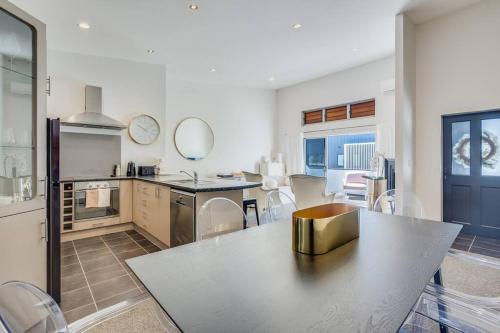 a kitchen with a table and chairs in a room at Golden Retreat, Central Mount Maunganui in Mount Maunganui