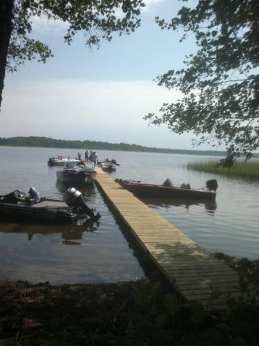 a dock with several boats on a lake at Kempings Mežmalas in Usma