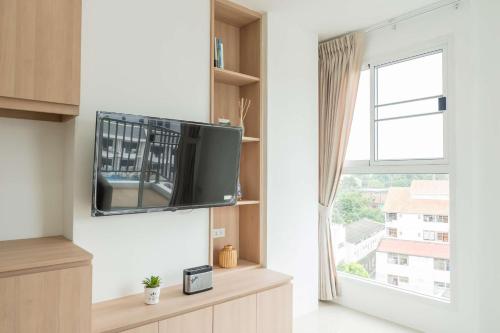 コーンケーンにあるJK Residence KKUのリビングルーム(壁にテレビ付)