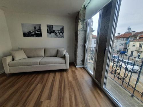 a living room with a couch and a large window at CASA OURO D'ALVA - Luxury Lodging, SPA & WELLNESS in Penalva do Castelo