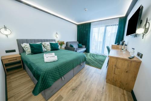 sypialnia z łóżkiem z zieloną narzutą w obiekcie SkyHel Apartamenty 101 w mieście Hel