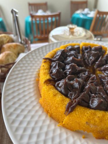 a chocolate pie on a white plate on a table at Pousada Pequeno Oásis in Tiradentes