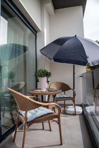 a table and chairs with an umbrella on a patio at Konstantins Apartment in Ohrid