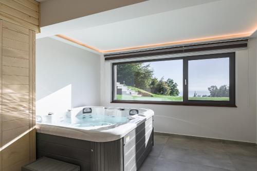a bath tub in a bathroom with a large window at Divine Forest in Litochoro