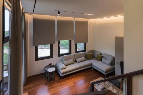 a living room with a couch and some windows at Divine Forest in Litochoro