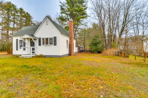 a small white house with a chimney on a yard at Ski, Hike and Fish Dog-Friendly Gem in Conway in North Conway