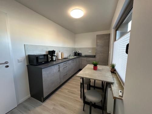 a small kitchen with a table and a microwave at FeWo Heerener Straße in Stendal