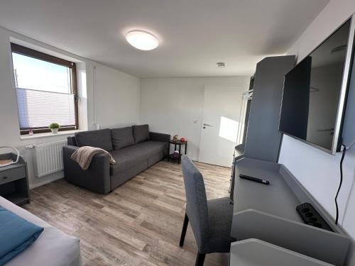a living room with a couch and a tv at FeWo Heerener Straße in Stendal
