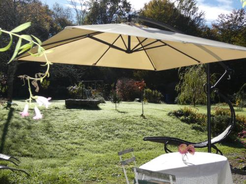 an umbrella sitting on a table in a yard at ESTUVI, une pause nature dans le Jura in Chemenot