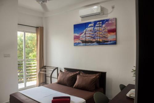 un dormitorio con una cama y una pintura de un barco en Solid Hotel Boralasgamuwa, en Boralesgamuwa