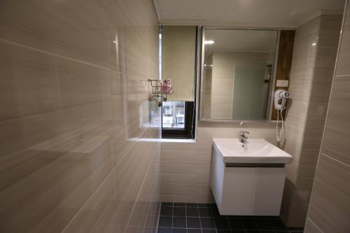 a bathroom with a sink and a mirror at Central Hotel in Zhongli