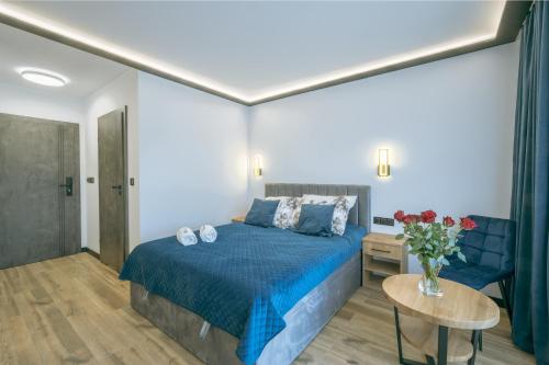 a bedroom with a bed and a table with a vase of flowers at SkyHel Apartament 102 in Hel