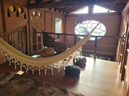 una habitación con una hamaca en una casa en Refúgio Terracota uma casa bioconstruída com arte, en Mairiporã