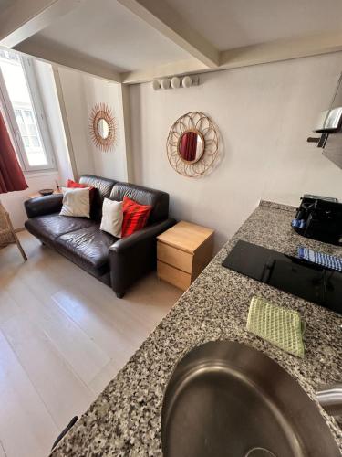 un salon avec un canapé en cuir noir et une table dans l'établissement Tranquil Studio with Mezzanine in Carre dOr, à Nice
