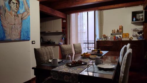 Una cocina con una mesa de comedor y un cuadro de un hombre. en B&B Palazzo Sant'Alfano, en Catania