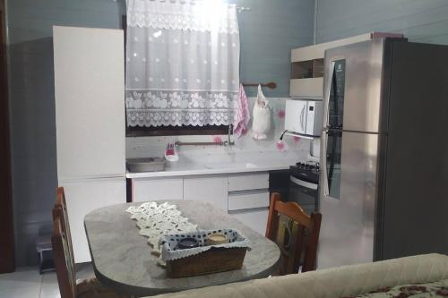 a kitchen with a table with a cake on it at Res Canto dos Pássaros - Chalé 03 in Rio Grande