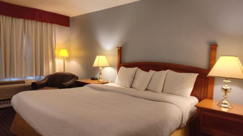 a hotel room with a large bed and two lamps at Metro Inn in Calgary