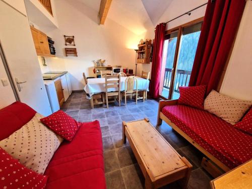 un salon avec deux canapés rouges et une table dans l'établissement Résidence Grand Argentier - 2 pièces + mezzanine 6/8 personnes 53m² MAE-2900, à Modane