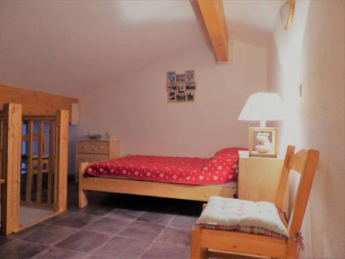 une chambre avec un lit, une lampe et une chaise dans l'établissement Résidence Grand Argentier - 2 pièces + mezzanine 6/8 personnes 53m² MAE-2900, à Modane
