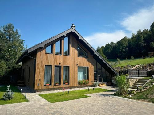 a large wooden house with a lot of windows at Chata pod Cigerníkom in Matiašovce