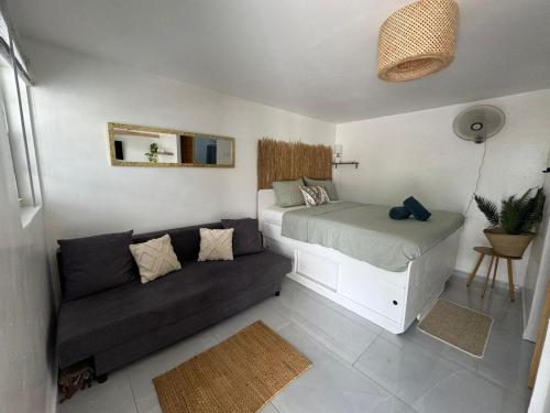 a small bedroom with a bed and a couch at 4BlessingsCuracao2 in Willemstad