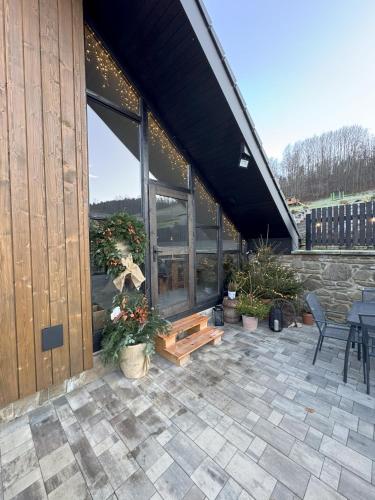 a patio with a table and chairs and a building at Chata pod Cigerníkom in Matiašovce