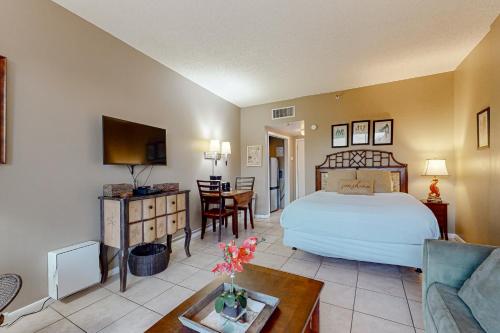 Un dormitorio con una cama y una sala de estar. en Pirates Bay B206, en Fort Walton Beach