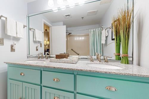 Un baño con dos lavabos y un espejo grande. en Pirates Bay B206, en Fort Walton Beach