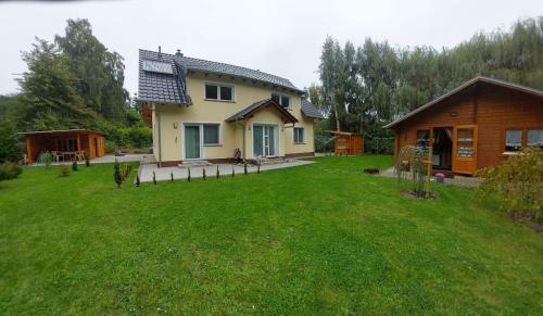 una casa con un gran patio con una casa en Muschel am Strand, en Breege