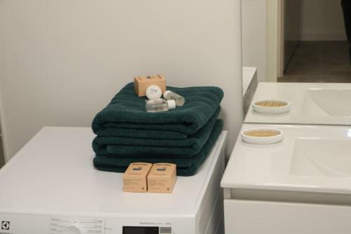 une pile de serviettes vertes assises au-dessus d'un comptoir dans l'établissement Cozy Luxe Villiers 10 minutes de paris - Proche Disneyland, à Villiers-sur-Marne