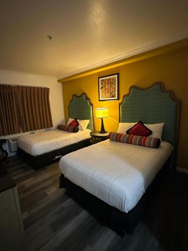 a hotel room with two beds and a lamp at Howard Johnson by Wyndham Bakersfield in Bakersfield