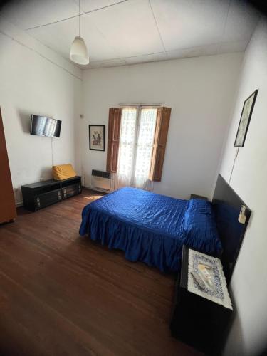 una camera da letto con un letto con un copriletto blu di Casa Alberdi a Colón