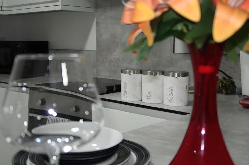 a red vase sitting on top of a kitchen counter at Bloom Court -Sleeps 6-Free Parking with Workspace & High-Speed WiFi in Birmingham