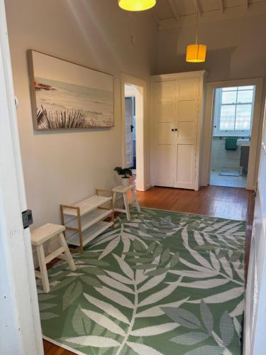 a living room with a table and chairs and a rug at 3 Bedroom Beach House in Coogee in Sydney