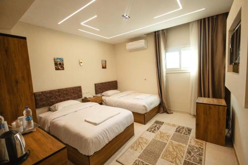 a hotel room with two beds and a window at The View Pyramids Gold one in Cairo